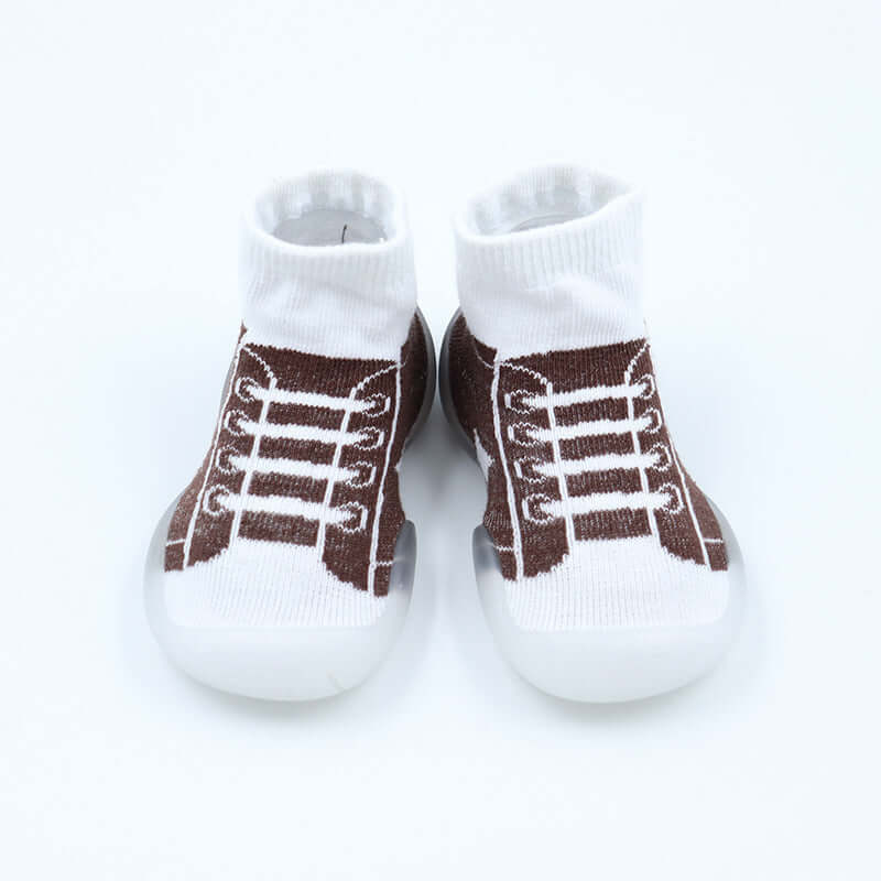 White baby socks with brown shoe laces on a white background