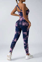 Person wearing a navy and pink tie-dye athletic outfit on a white background