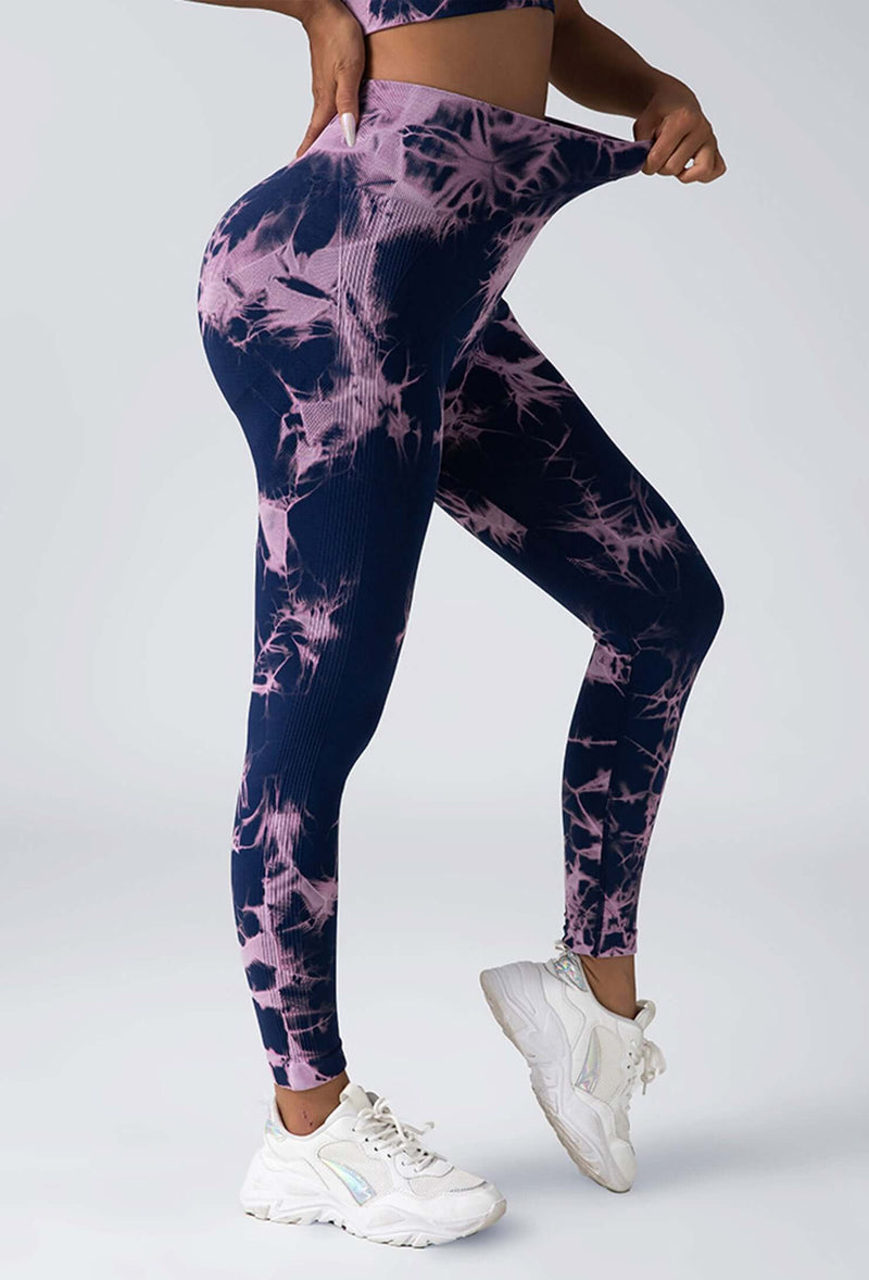 Person wearing tie-dye leggings and white sneakers on a white background