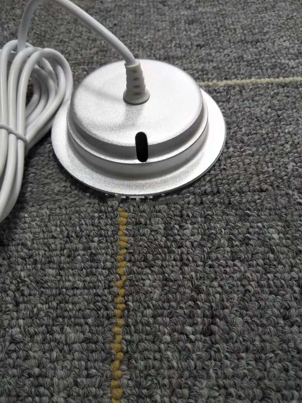 White cylindrical object with a cord on a textured gray surface