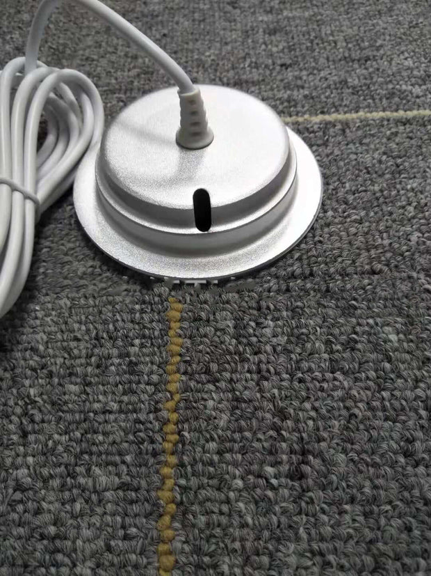 White cylindrical object with a cord on a textured gray surface