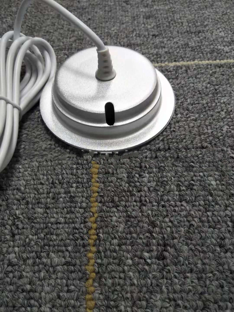 White cylindrical object with a cord on a textured gray surface