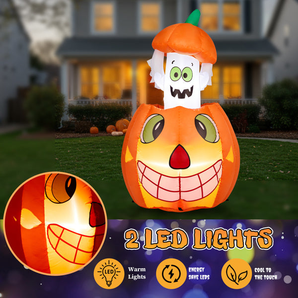 Inflatable pumpkin with ghost face design on a grassy lawn in front of a house.