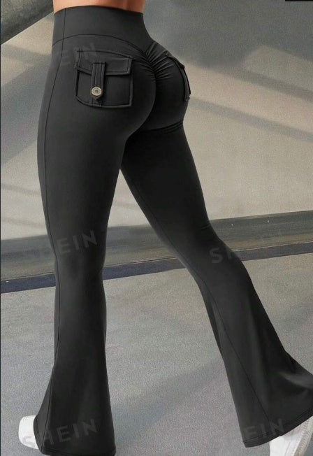 Black flared pants being worn on a neutral background