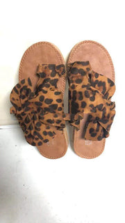 Pair of sandals with leopard print straps on a white background