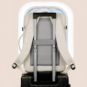 Backpack with rolling handle on a suitcase against a beige background