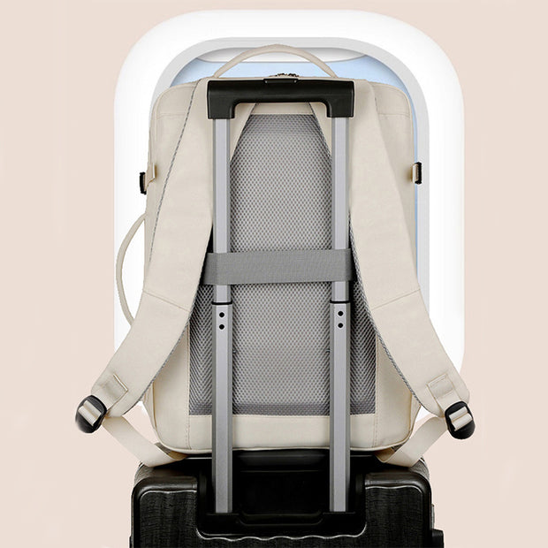 Backpack with rolling handle on a suitcase against a beige background