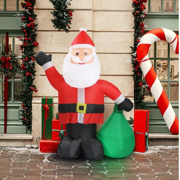 Inflatable Santa Claus decoration in front of a building with Christmas decorations.
