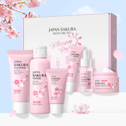 Japan Sakura skincare set with various products on a light blue background with cherry blossoms.