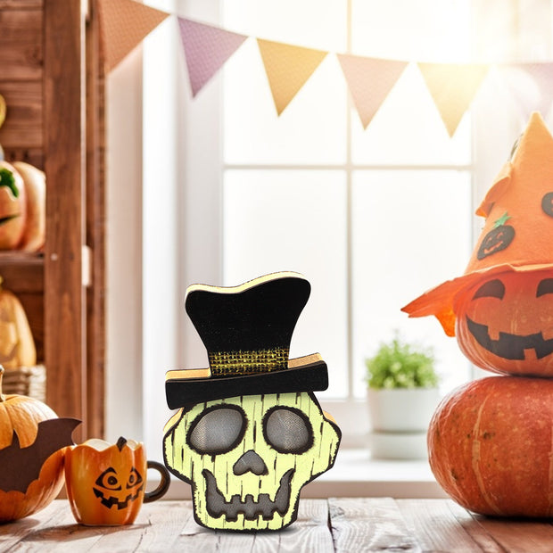 Decorative skull with a top hat on a table with pumpkins and a bunting in the background