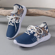 Blue sneakers with white soles and patterned design on a gray surface