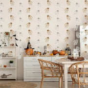 Dining room with Halloween decorations, including pumpkins and black hats, against a wallpapered wall.