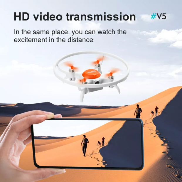 Drone hovering over a desert with a person holding a phone watching a video of people walking in the distance.
