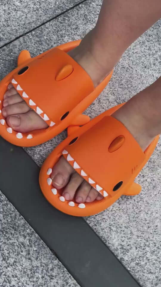 Fun orange cartoon shark slippers for adults, featuring open toes and a playful design, perfect for indoor and outdoor wear.